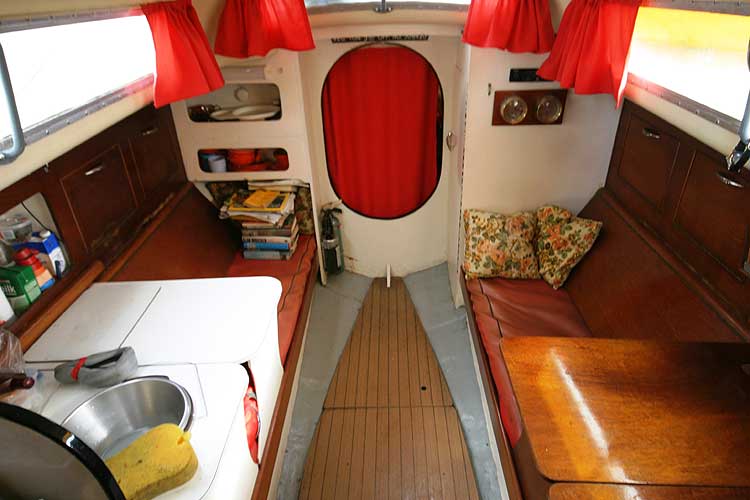 Van de Stadt Pioneer 9for sale Main saloon looking forward - Note the attractive wooden cabin sole, and the galley on the port side.